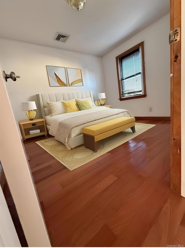 Bedroom featuring wood finished floors and baseboards