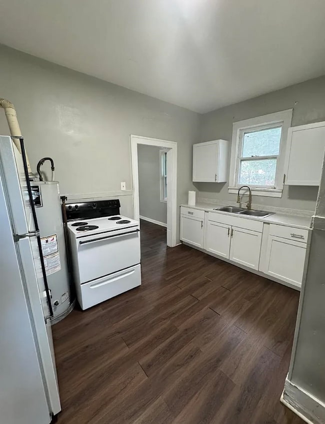 Kitchen featuring white cabinetry, electric stove, light countertops, dark wood finished floors, and refrigerator