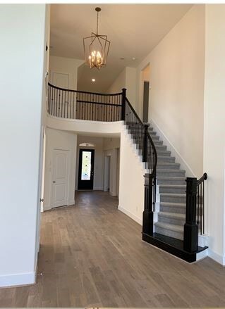 Distinctive curves staircase with stained trim and bold balusters