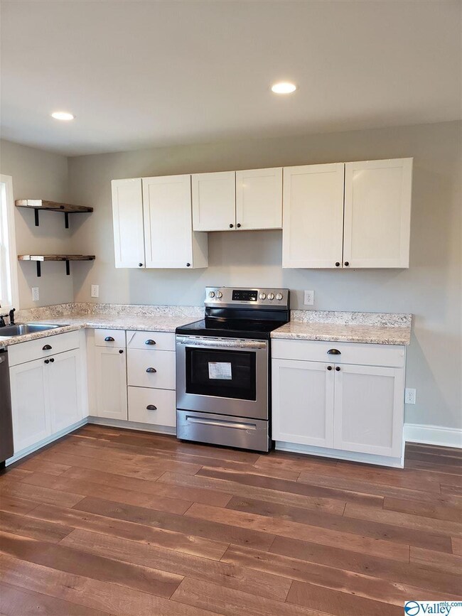 All new white kitchen with stainless steel range and dishwasher.
