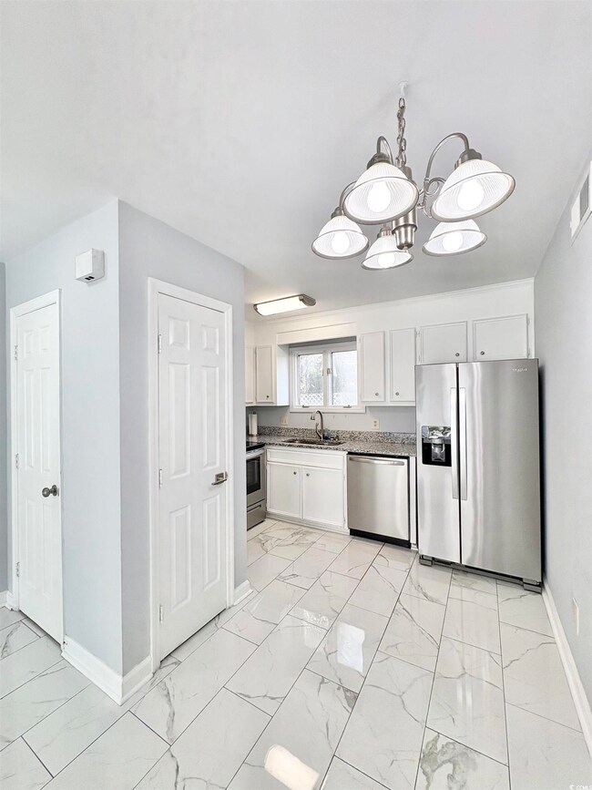 Kitchen with marble finish floor, a sink, stainles