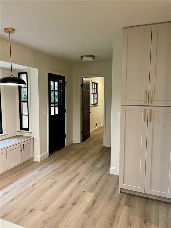 Foyer featuring light wood finished floors and baseboards