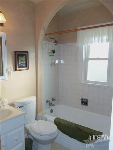 The bathroom is spacious and features a ceramic ti