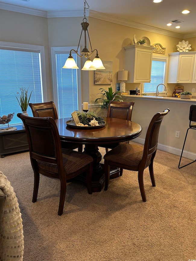 Dining room featuring light carpet, visible vents,