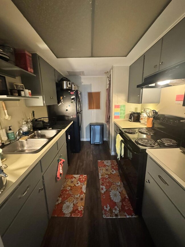 Kitchen featuring gray cabinets, black range with