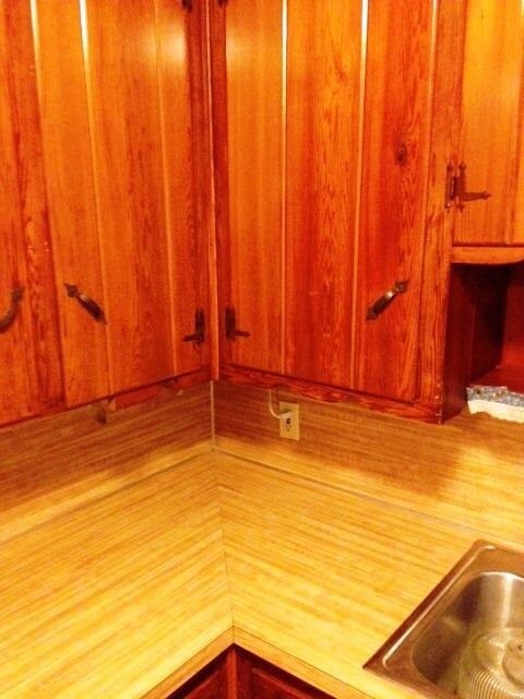 Lots of polished knotty pine cabinets in kitchen.