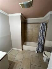 Bathroom with visible vents, crown molding, toilet