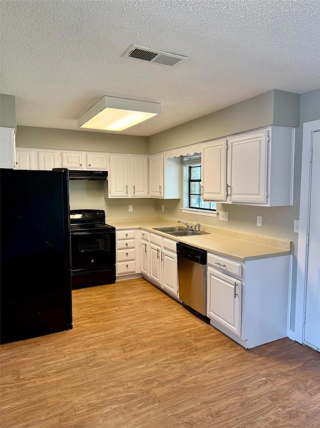 Kitchen with a textured ceiling, visible vents, a