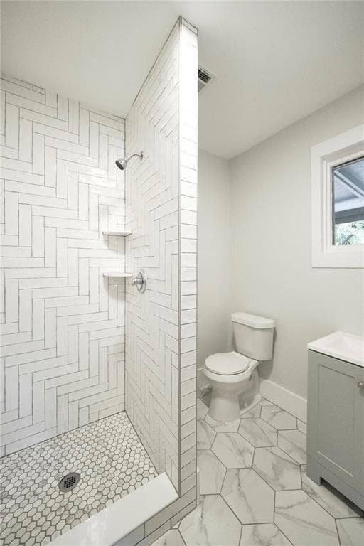 Bathroom featuring a stall shower, toilet, vanity