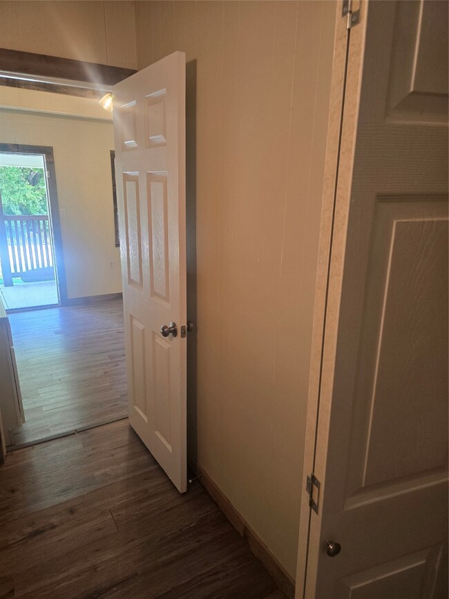 Corridor featuring baseboards and dark wood-type flooring