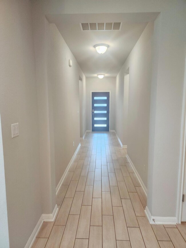Hall with light wood-style floors and baseboards