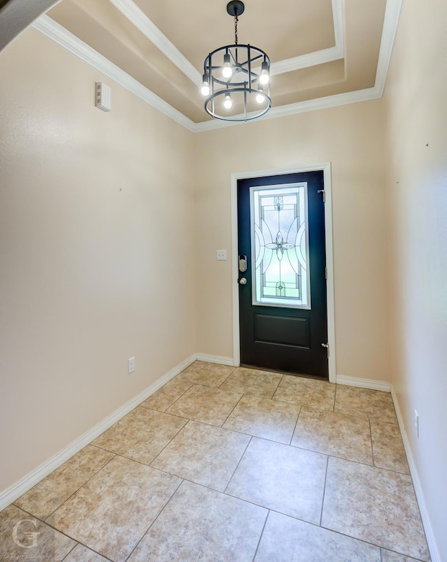 Tiled foyer entrance featuring a notable chandelie