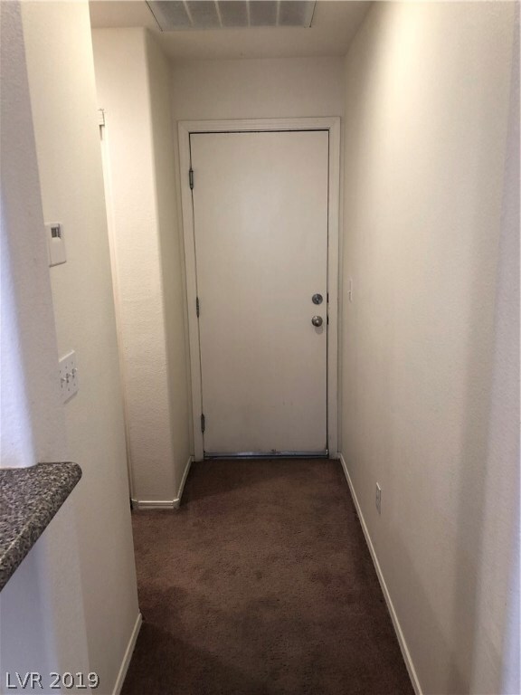 Door to the garage and to the left is a storage cl