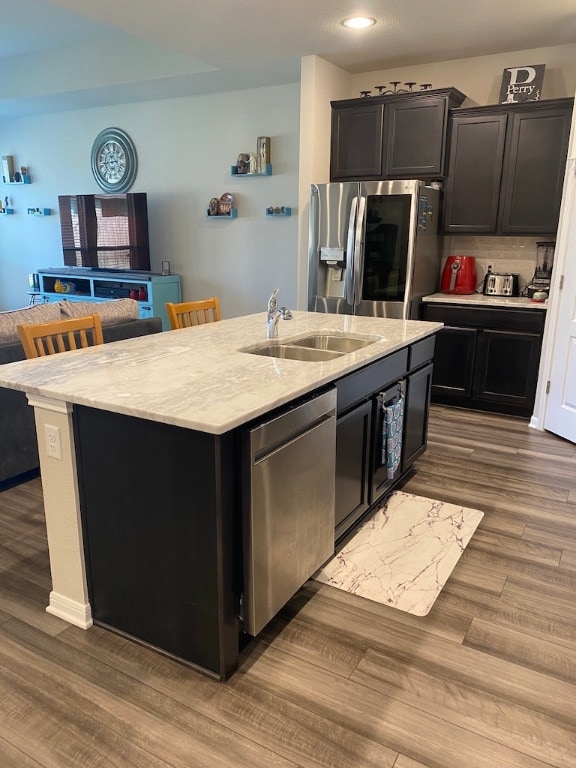Kitchen featuring an island with sink, light stone