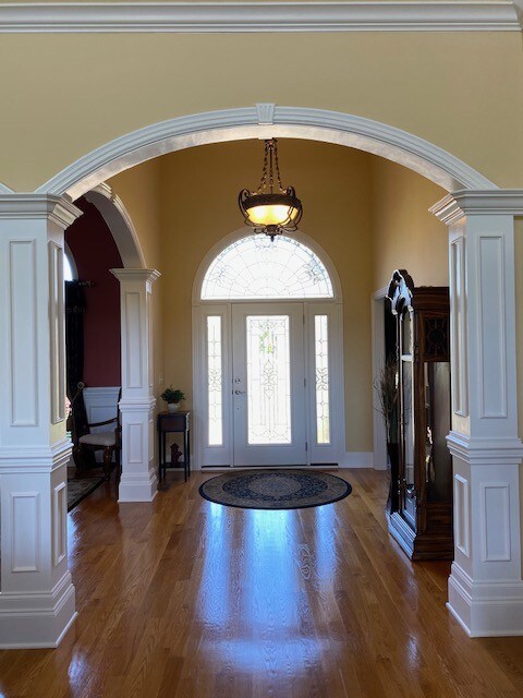 The cut glass arched entry door opens to the large open foyer.