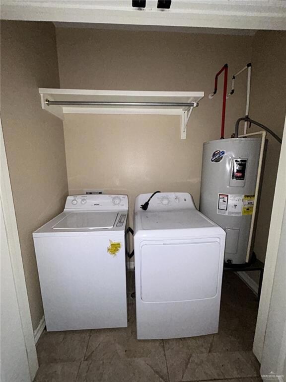 Laundry area with water heater and washer and clothes dryer