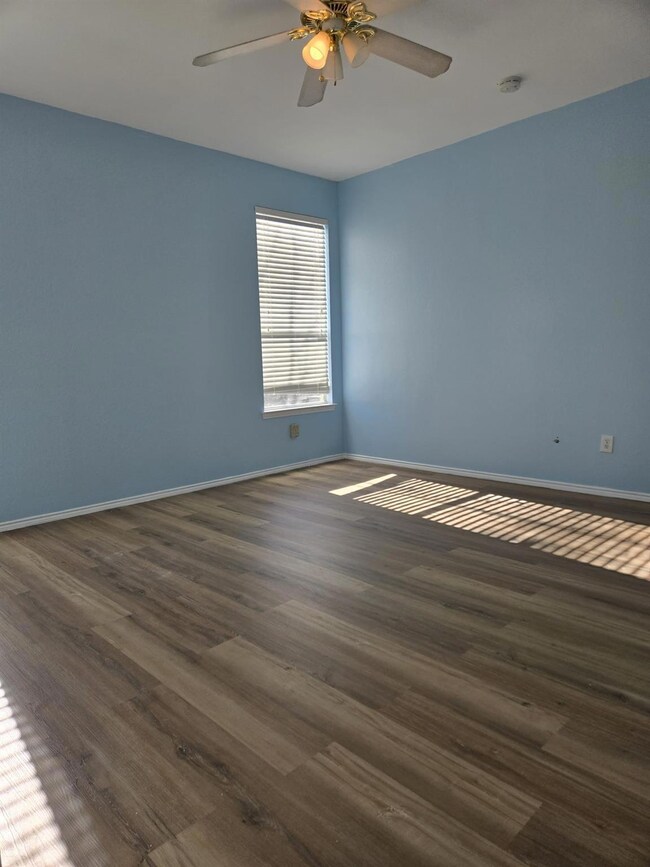 Empty room with ceiling fan and dark hardwood / wo