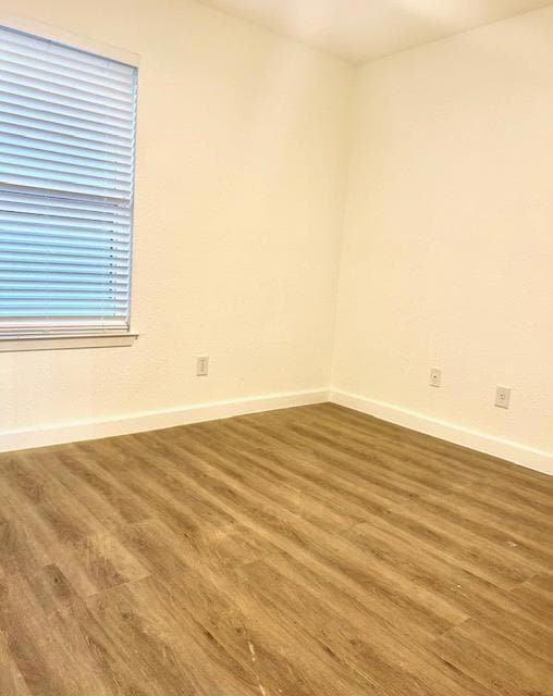 Spare room with wood finished floors and baseboar