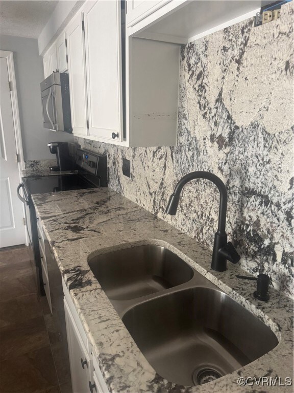 Room details featuring a sink, backsplash, light s