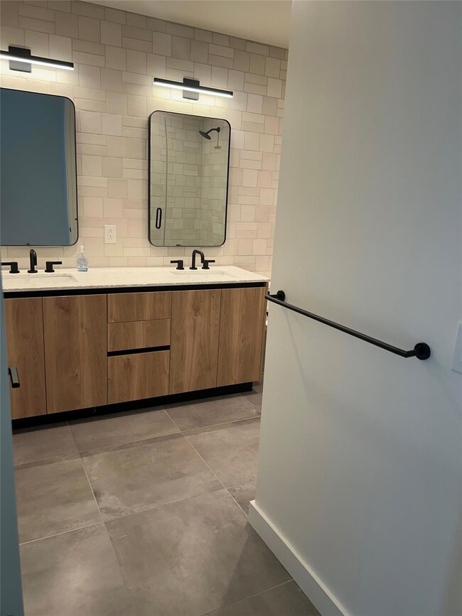 Bathroom featuring double vanity, baseboards, a s