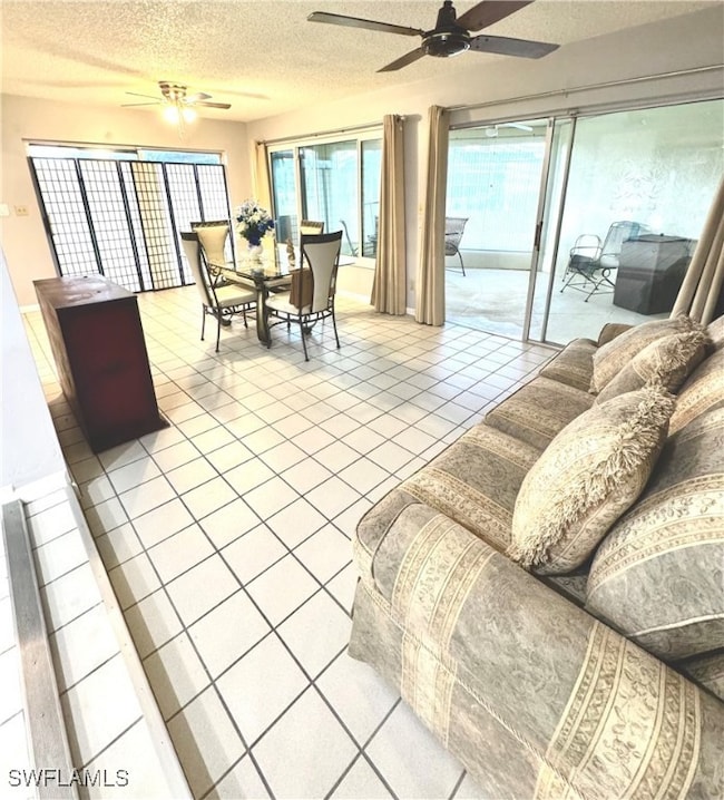 Living area with a ceiling fan, a textured ceiling