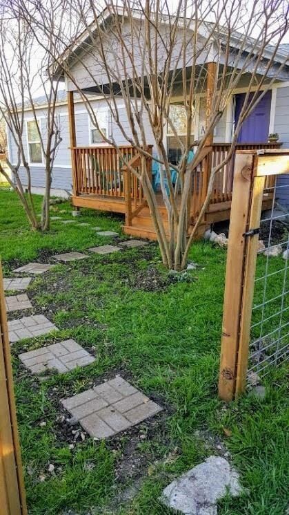 View of grassy yard with a wooden deck