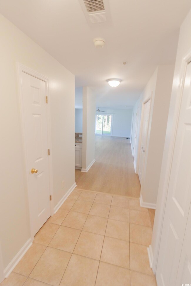 Hallway with baseboards and light tile patterned floors