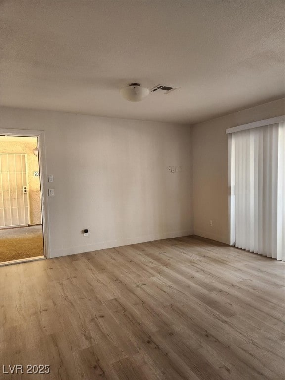 Unfurnished room with wood finished floors and bas