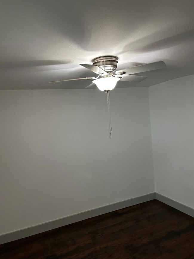 Spare room with dark wood-type flooring, a ceiling