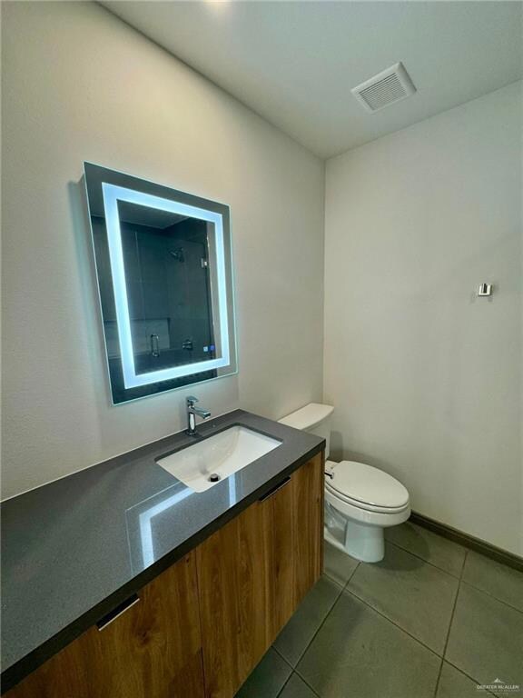 Bathroom with vanity, toilet, and tile floors