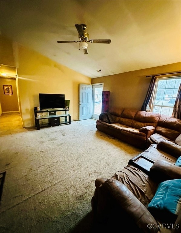 Carpeted living room featuring vaulted ceiling and