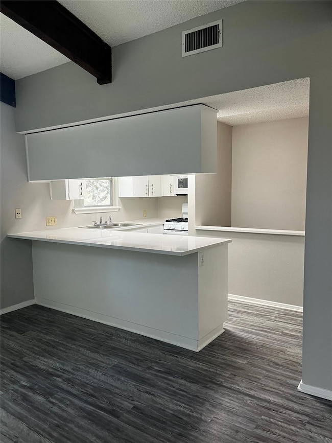 Kitchen with a textured ceiling, dark wood-style 