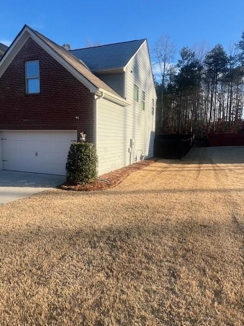 View of property exterior with concrete driveway