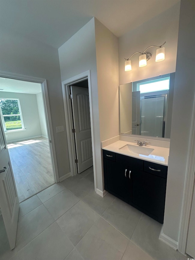 Bathroom with vanity, tile patterned flooring, and baseboards
