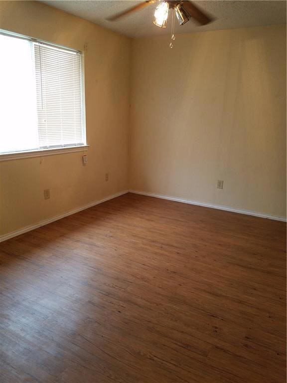 Empty room with a ceiling fan, wood finished floo