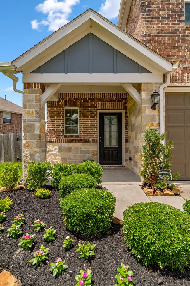 Beautiful landscaping leads to a covered front por