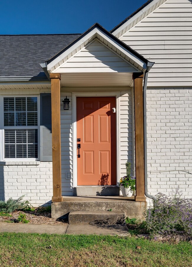 Covered front porch with minimal steps and colorful painted front door! A perfect way to greet guests.