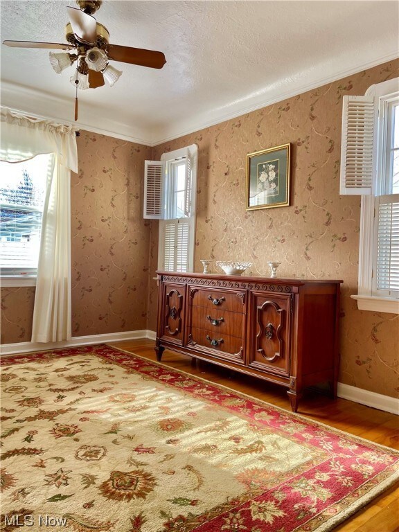 Dining room with ample natural light, hardwood flooring, and crown molding