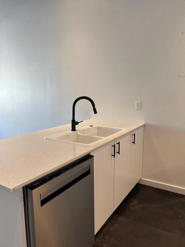 Kitchen with kitchen peninsula, light stone counte