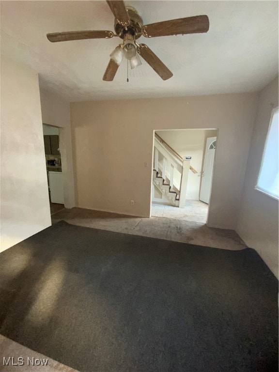Unfurnished room featuring stairway and ceiling fan