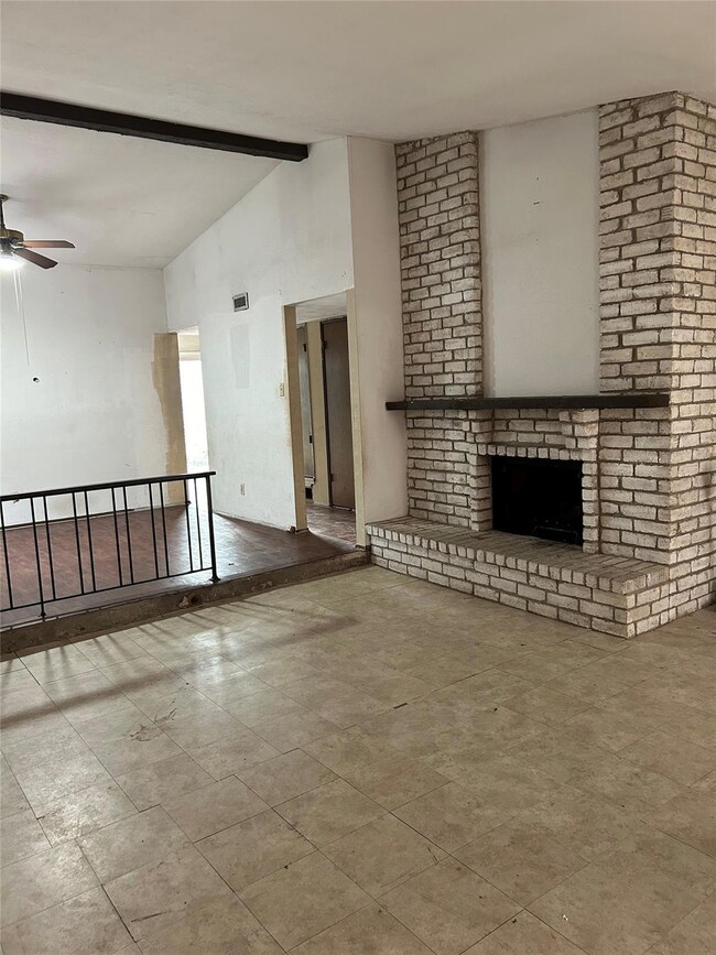 Unfurnished living room with ceiling fan and a bri