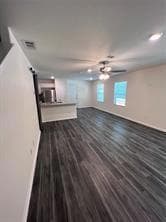 Unfurnished living room featuring ceiling fan, bas