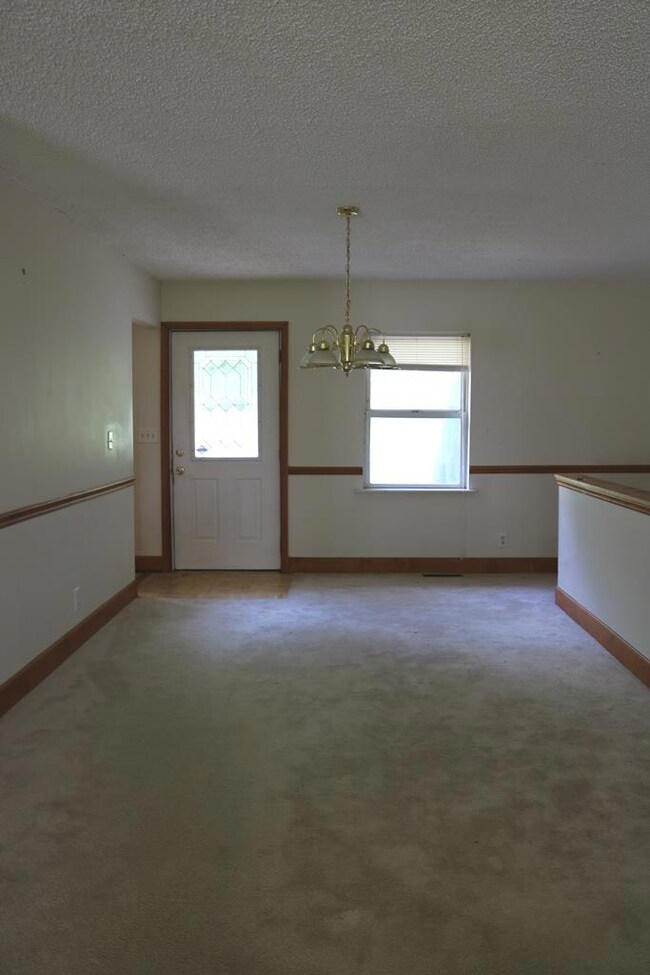 A view of the dining room. This whole living area can be easily updated with new floor covering, paint and light fixtures!