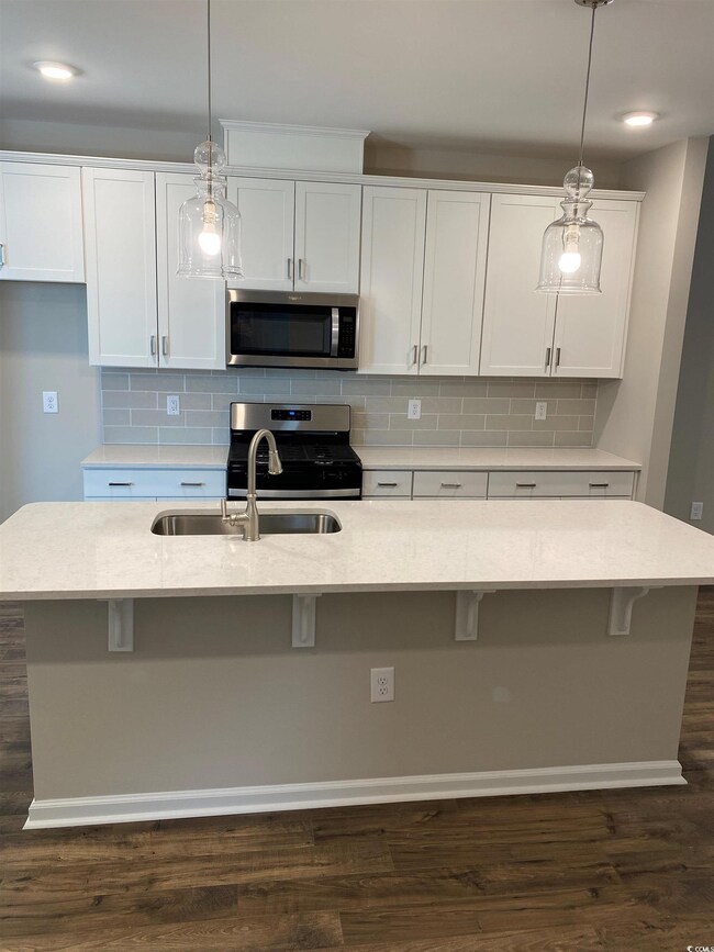 Kitchen featuring white cabinetry, an island with 