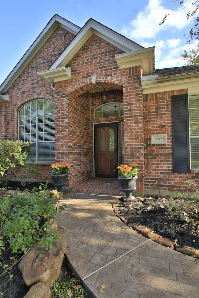 The landscaped front yard includes a stamped concrete walkway and tasteful planters, creating an inviting curb appeal.