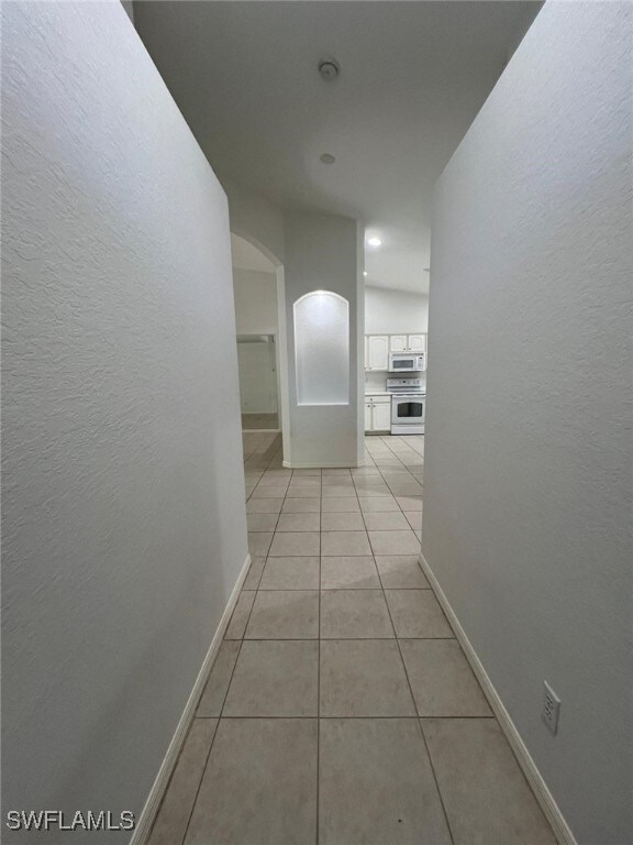 Hallway featuring light tile patterned flooring