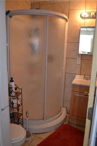 1st Floor full bath with tile flooring and walls.