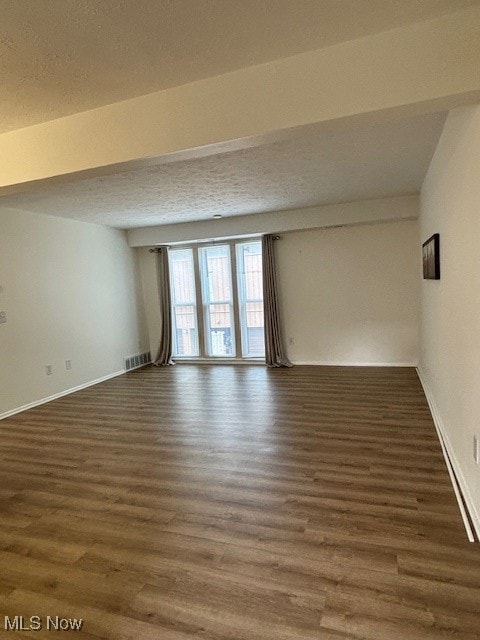 Spare room featuring a textured ceiling and wood finished floors