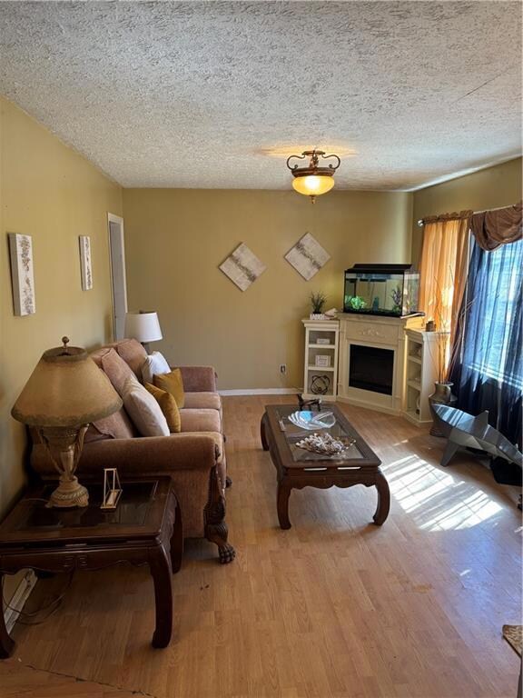 Living area with a fireplace, a textured ceiling, 