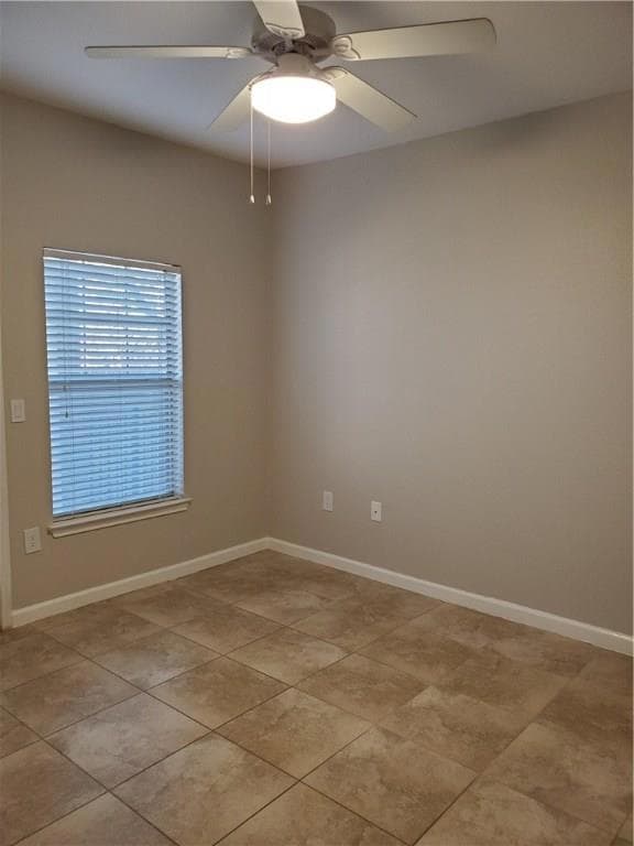 Unfurnished room with ceiling fan, light tile pat